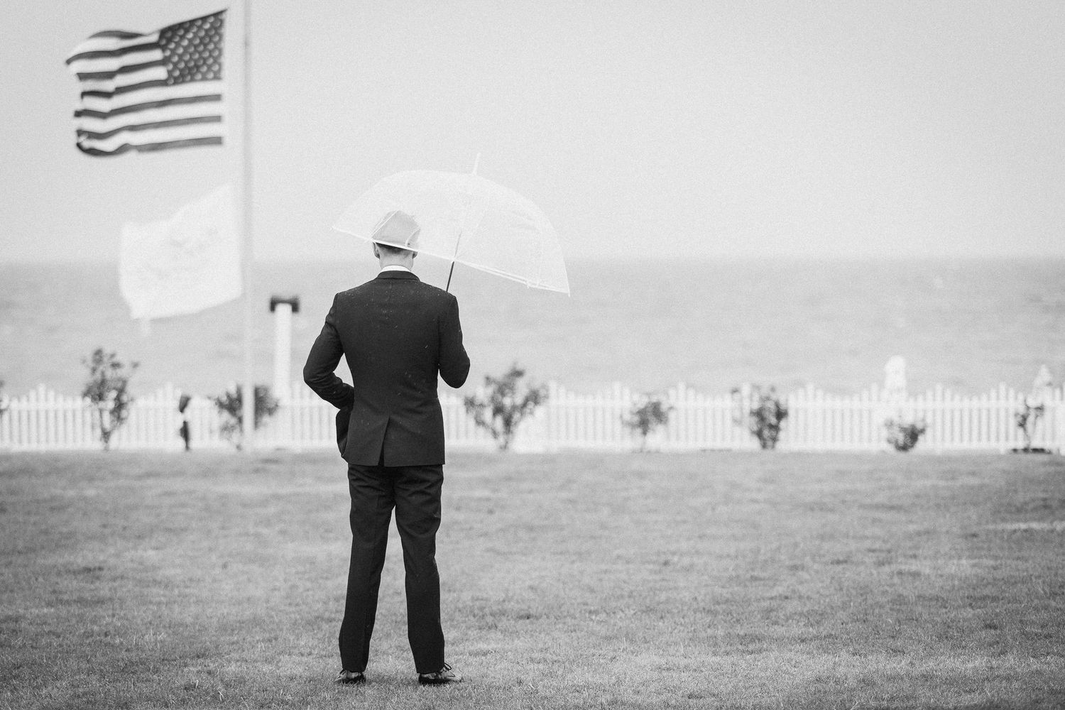 American flags wave in the background of an outdoor wedding ceremony setting.
