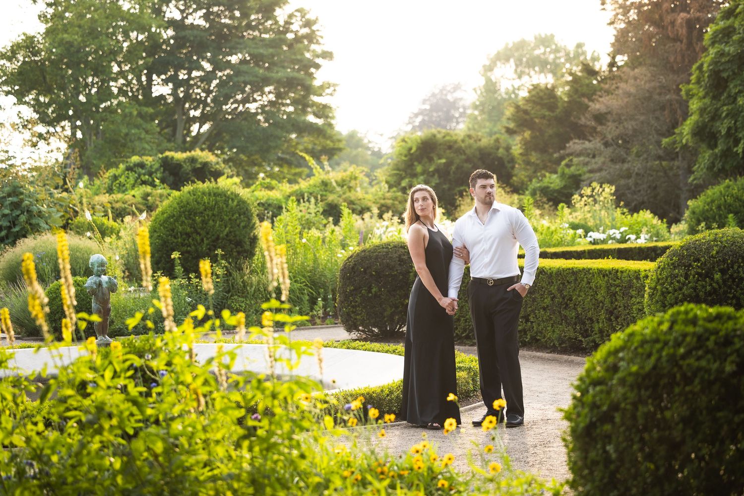 A couple enjoying a romantic moment together in a lush garden setting during golden hour.