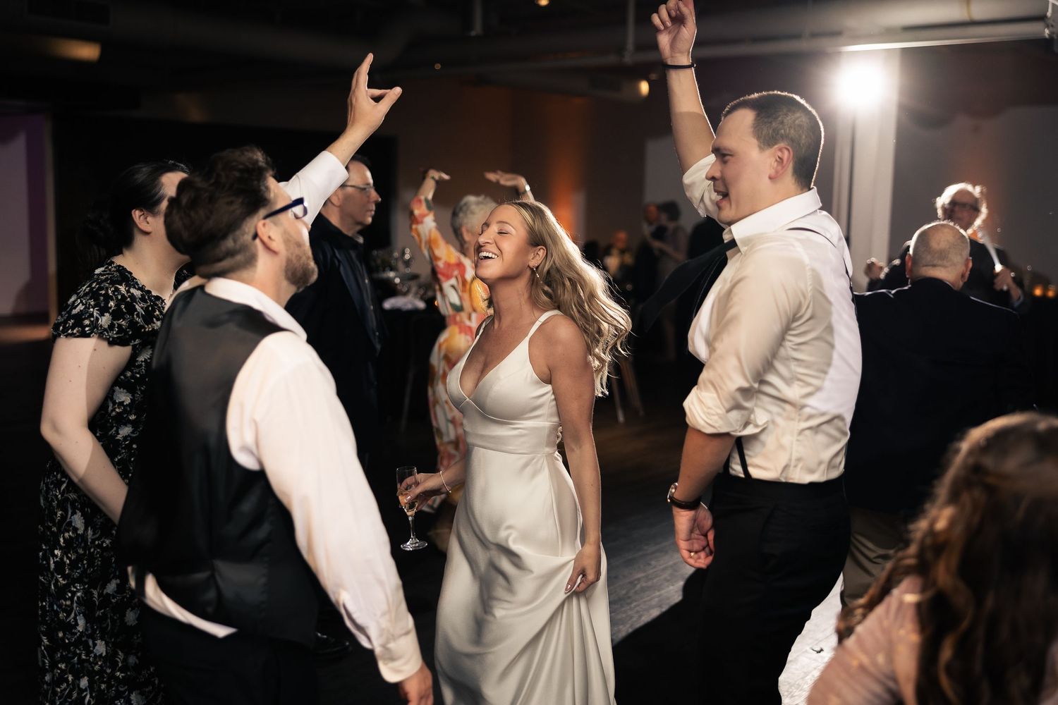 Couples dancing and celebrating at an elegant wedding reception in formal attire.