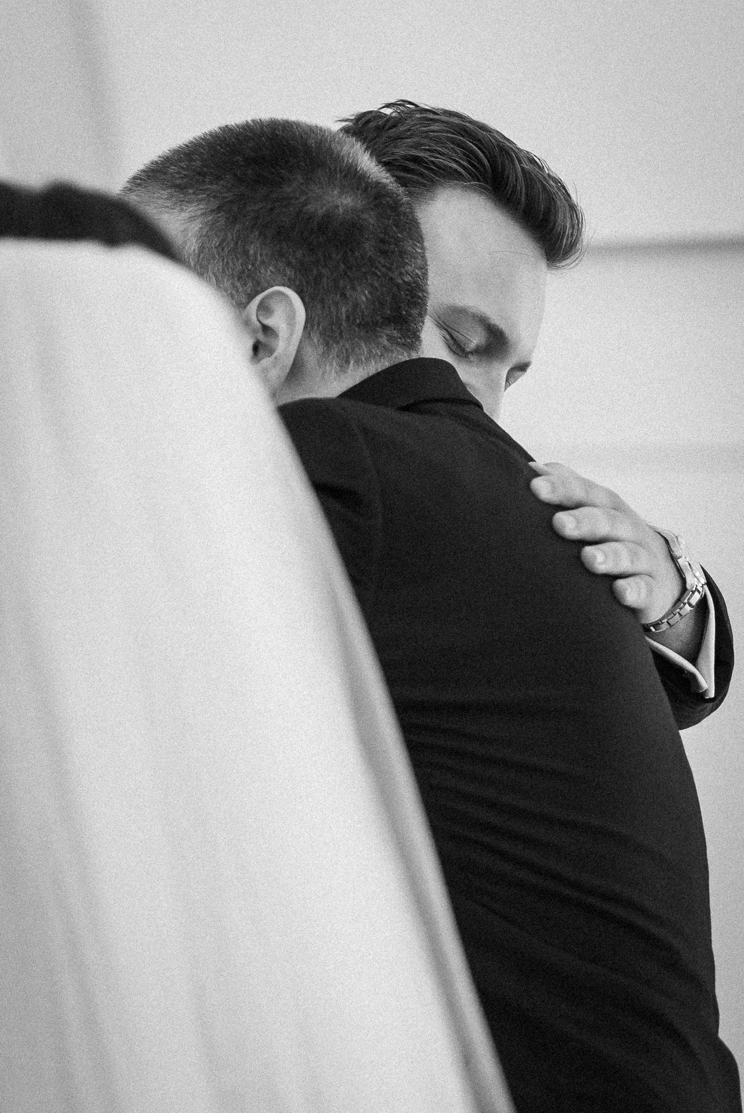 Black and white artistic close-up of emotional wedding moment.