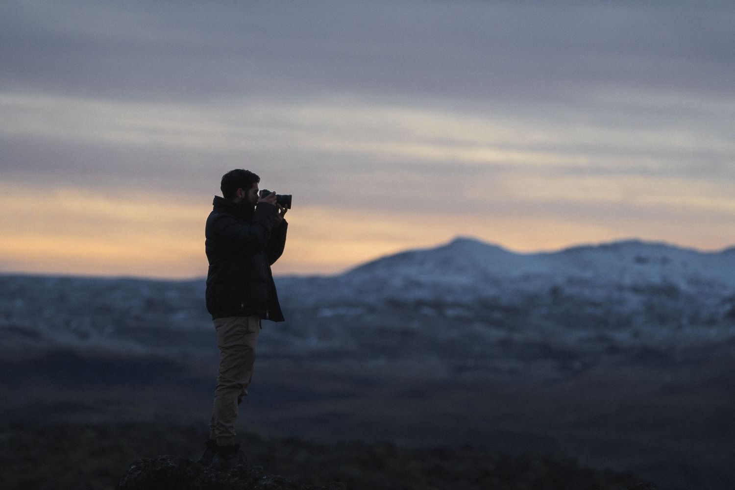 Mountain landscape at dusk creates dramatic backdrop for outdoor wedding photography.