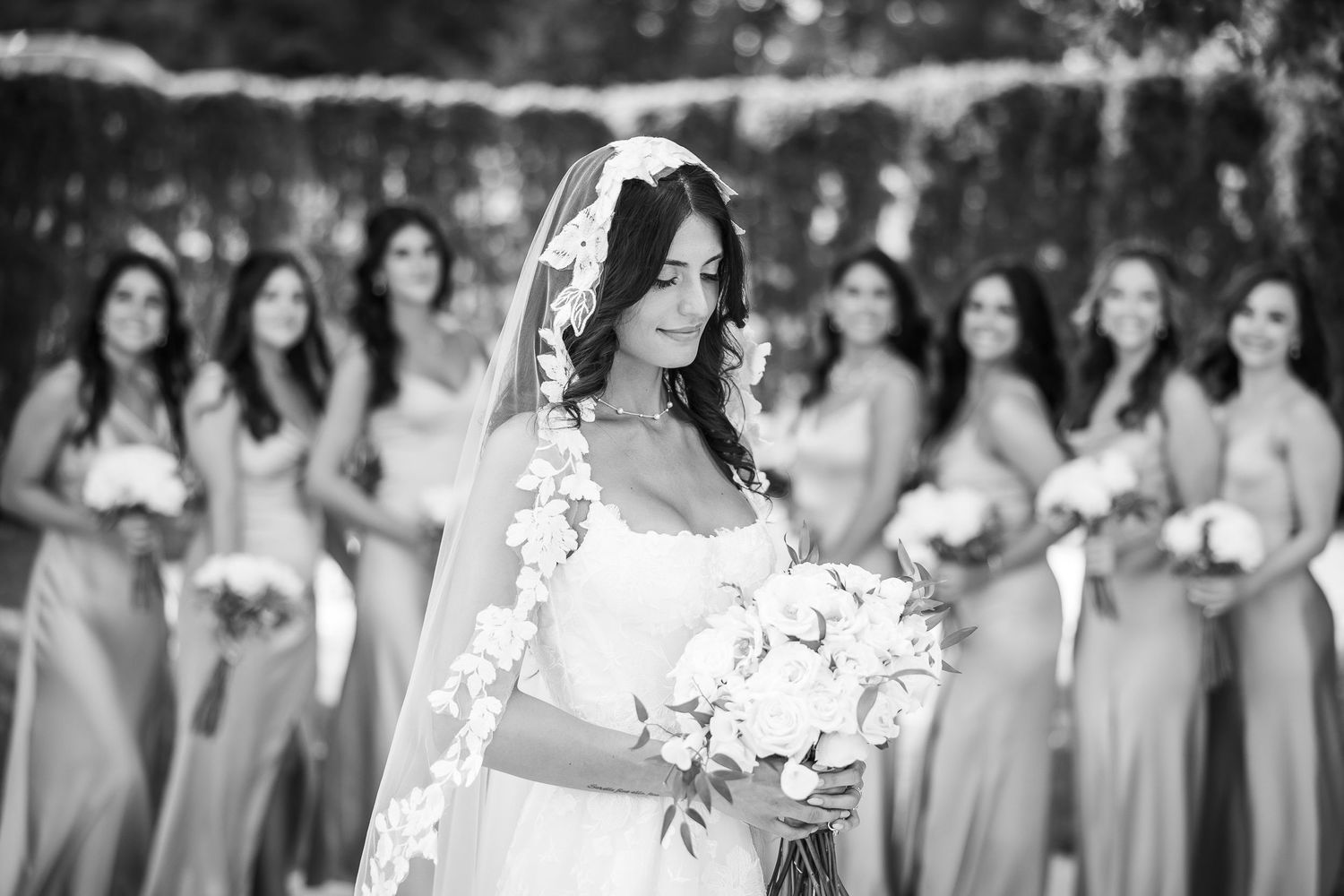 Wedding party in matching gray dresses poses outdoors.