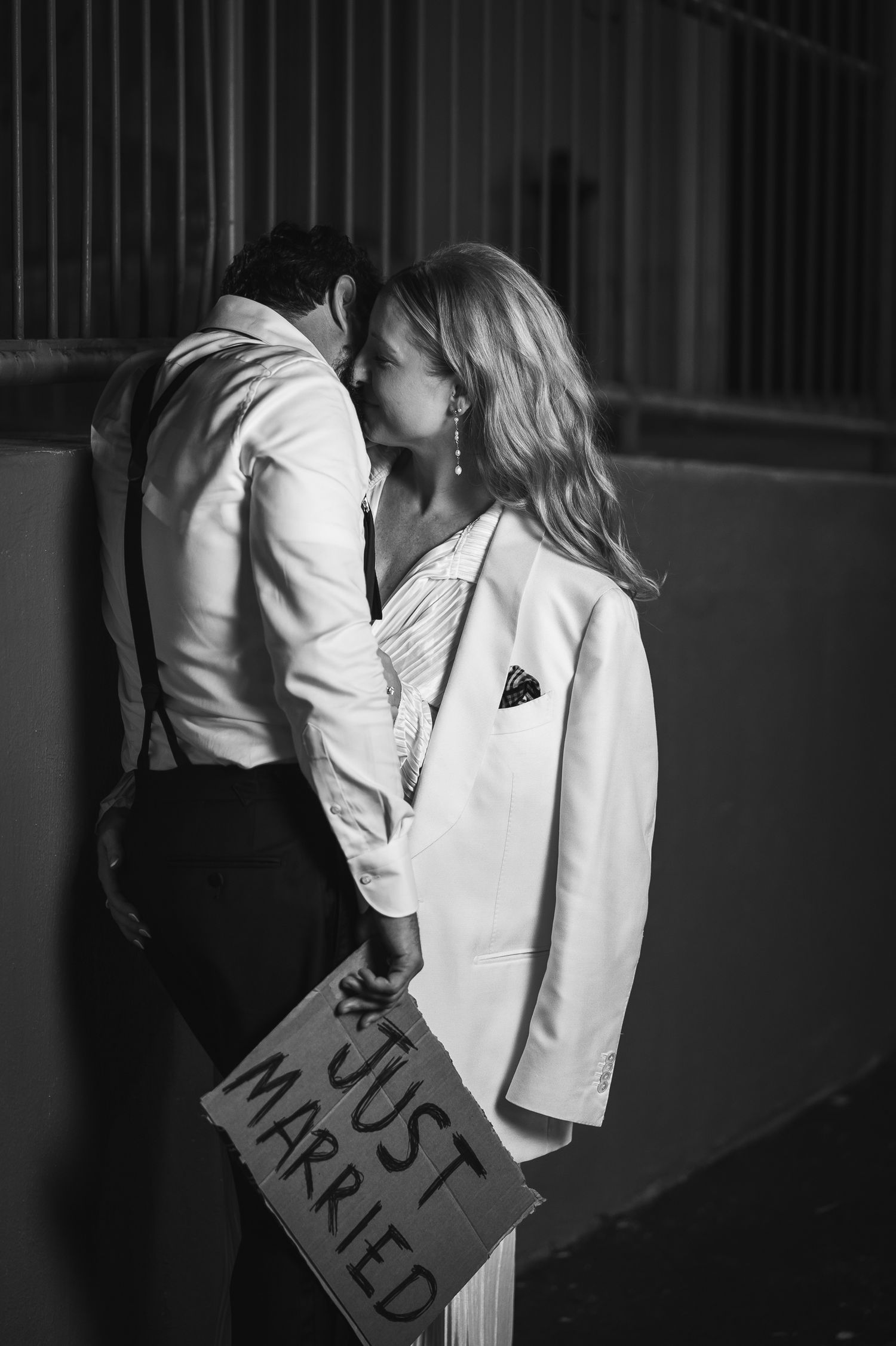 A black and white photo series showing a couple in wedding attire sharing romantic kisses and embraces.
