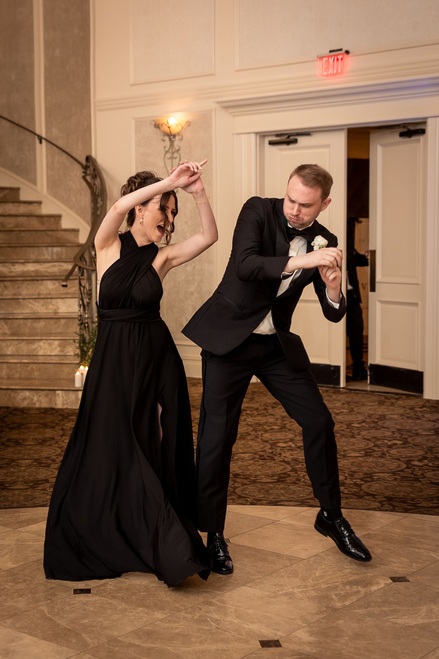 Couple performing dramatic dance moves on a ballroom floor.