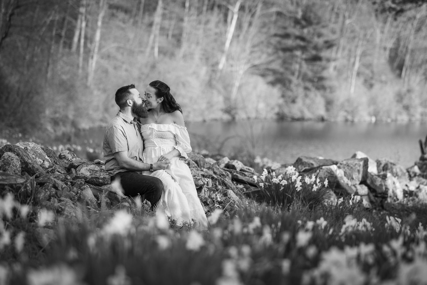 A romantic black and white photo series showing a couple embracing in a wildflower meadow.