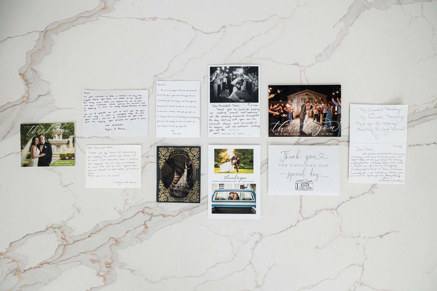 Wedding photos and handwritten notes arranged on white marble surface.