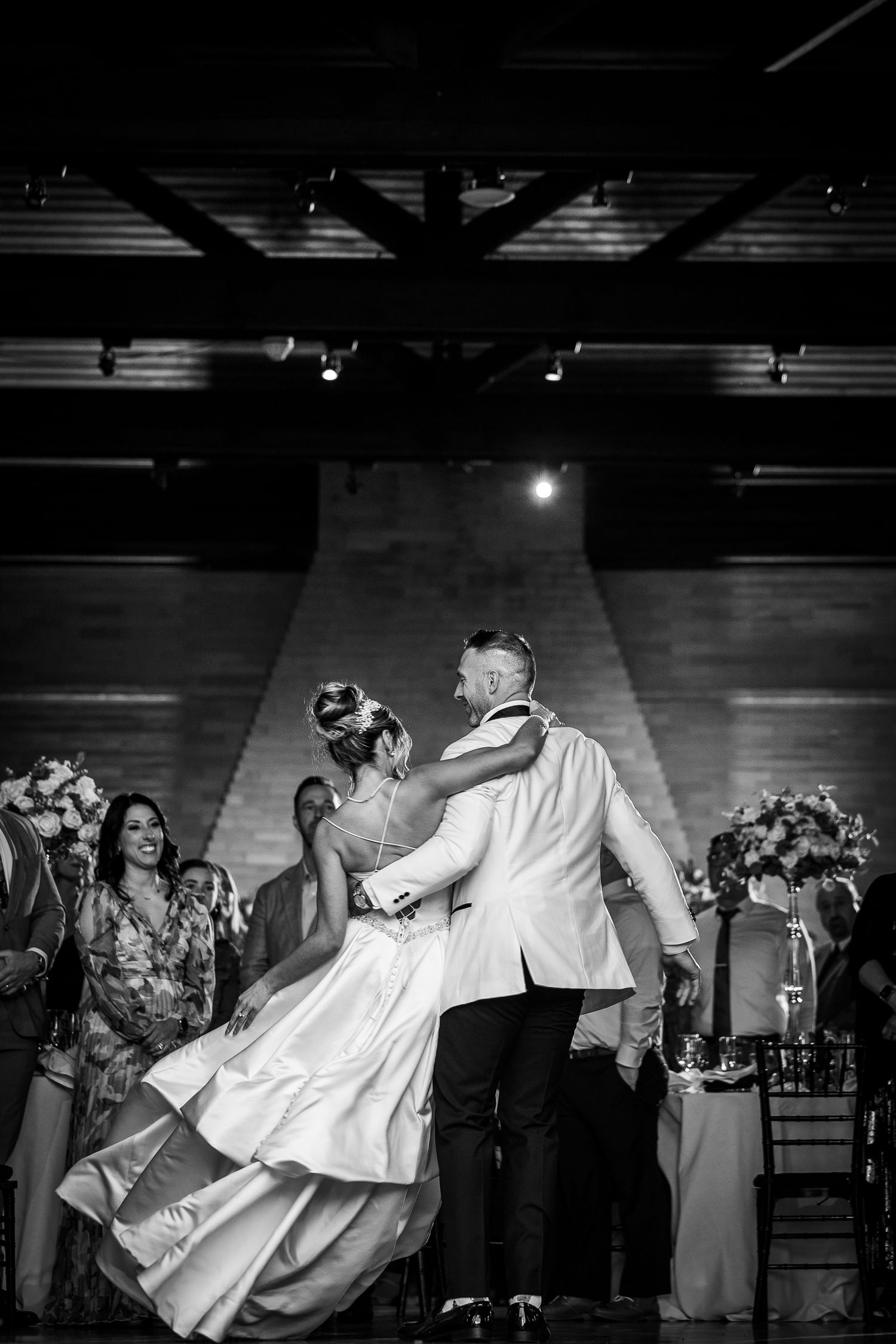 Dramatic black and white dance sequence at a wedding reception shows energetic movement on the dance floor.
