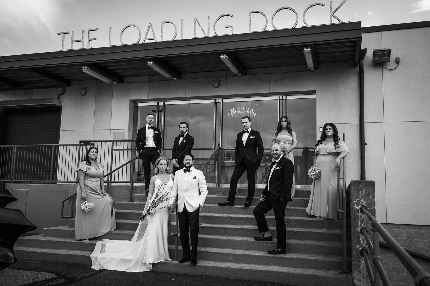 Black and white wedding party walking down a hallway in formal attire.