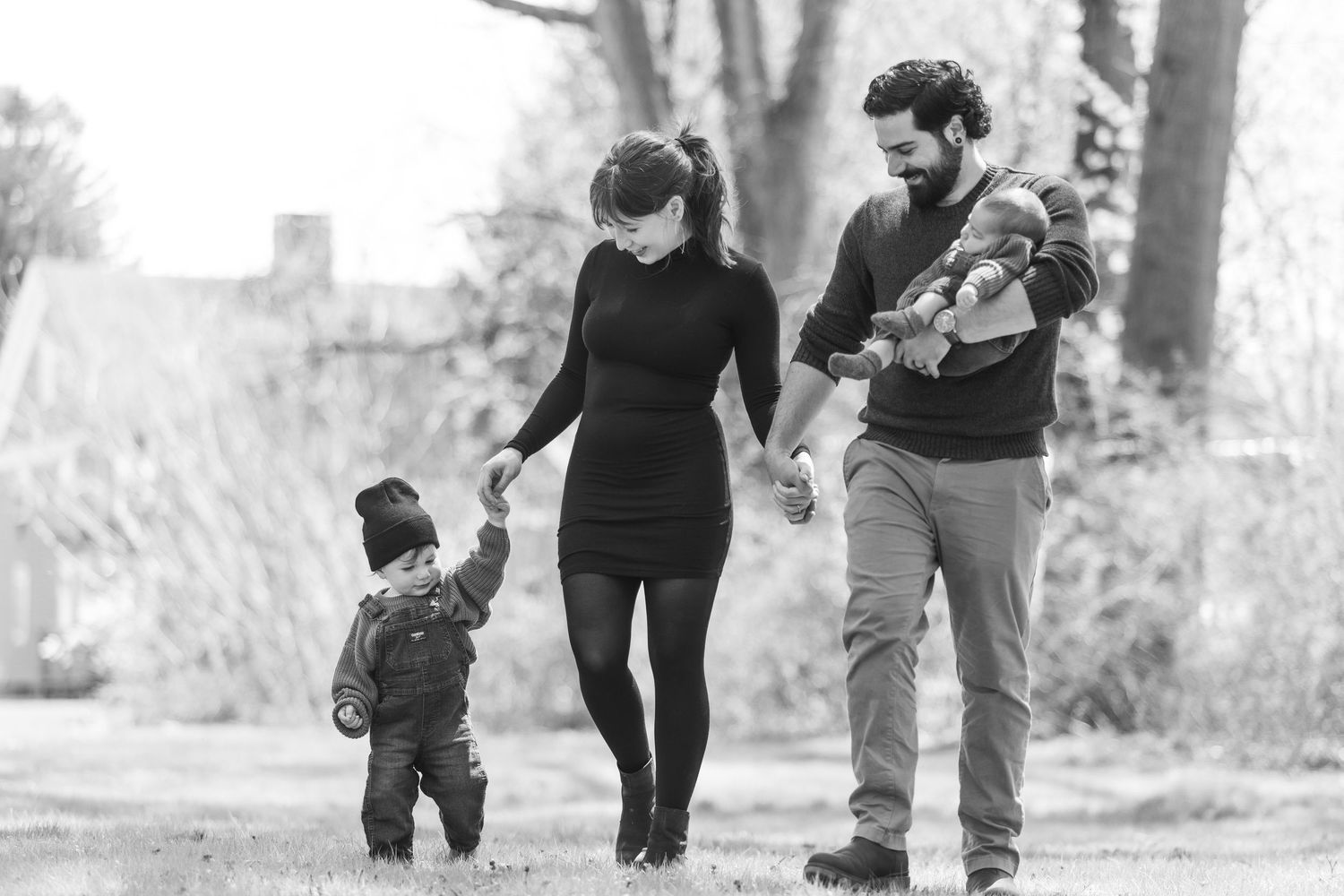 Family members walking together outdoors on a path through nature during a sunny autumn day.