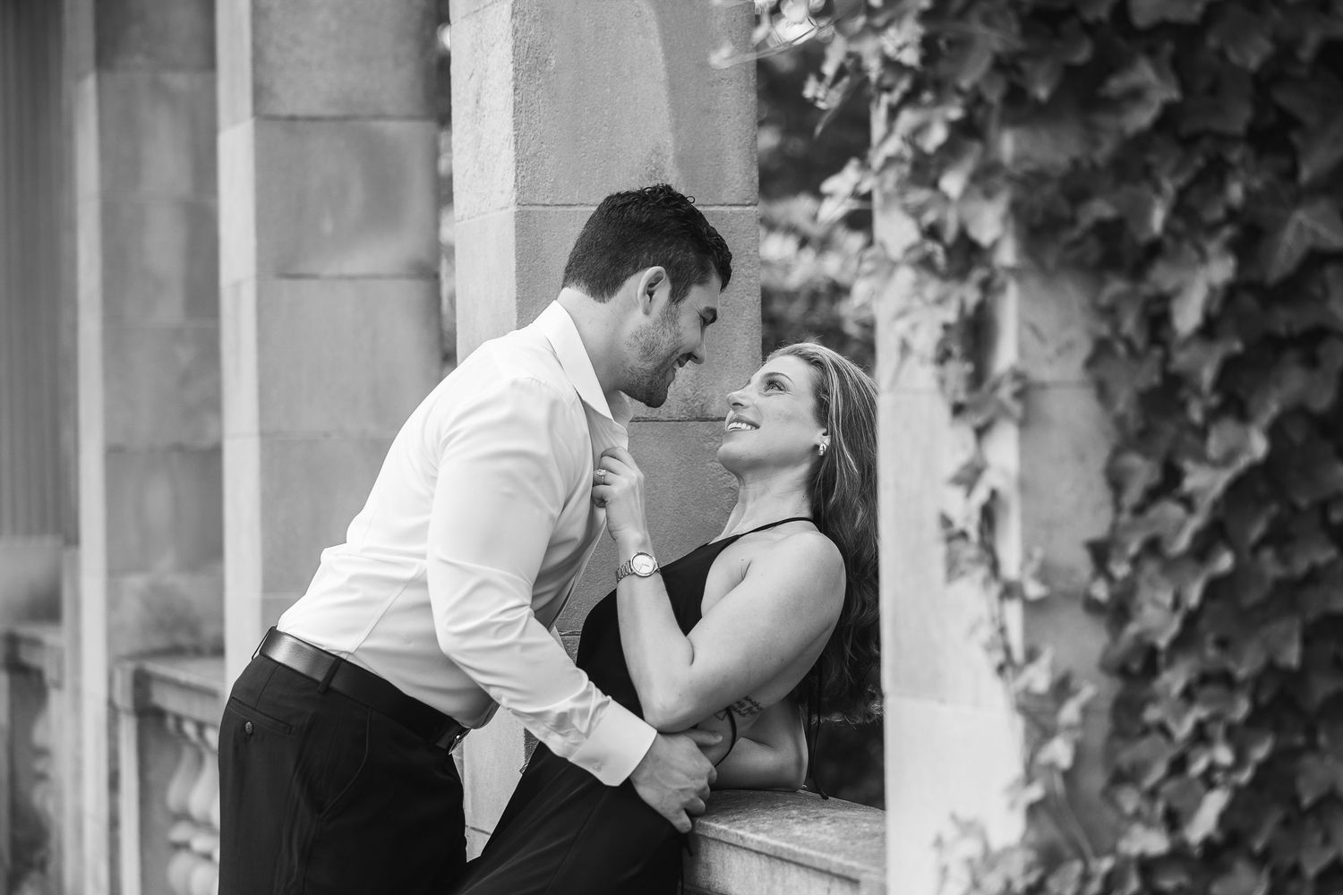 A romantic black and white photo series of a couple sharing intimate moments in an outdoor garden setting.