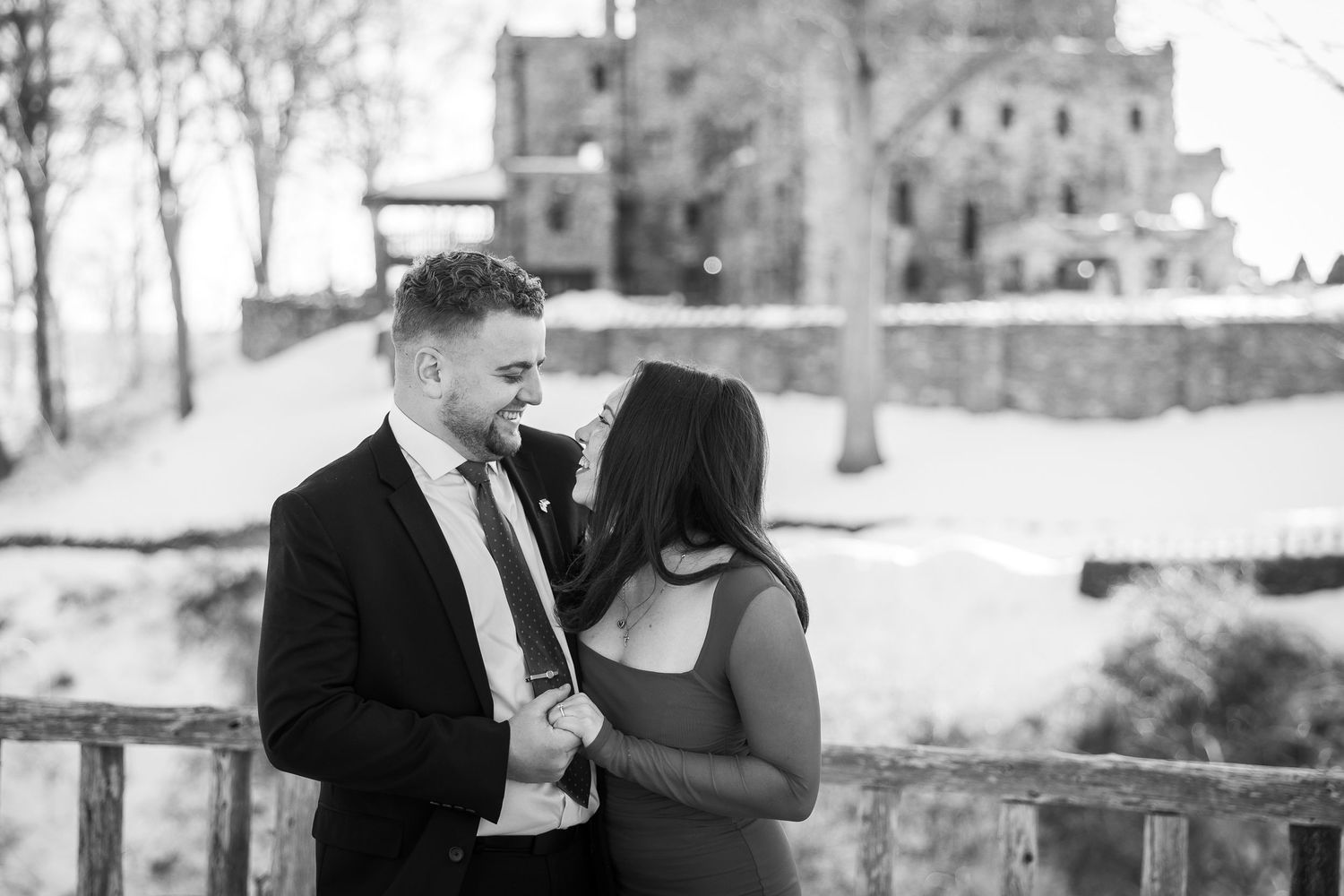 Black and white wedding photos show romantic moments between a couple in an outdoor setting.
