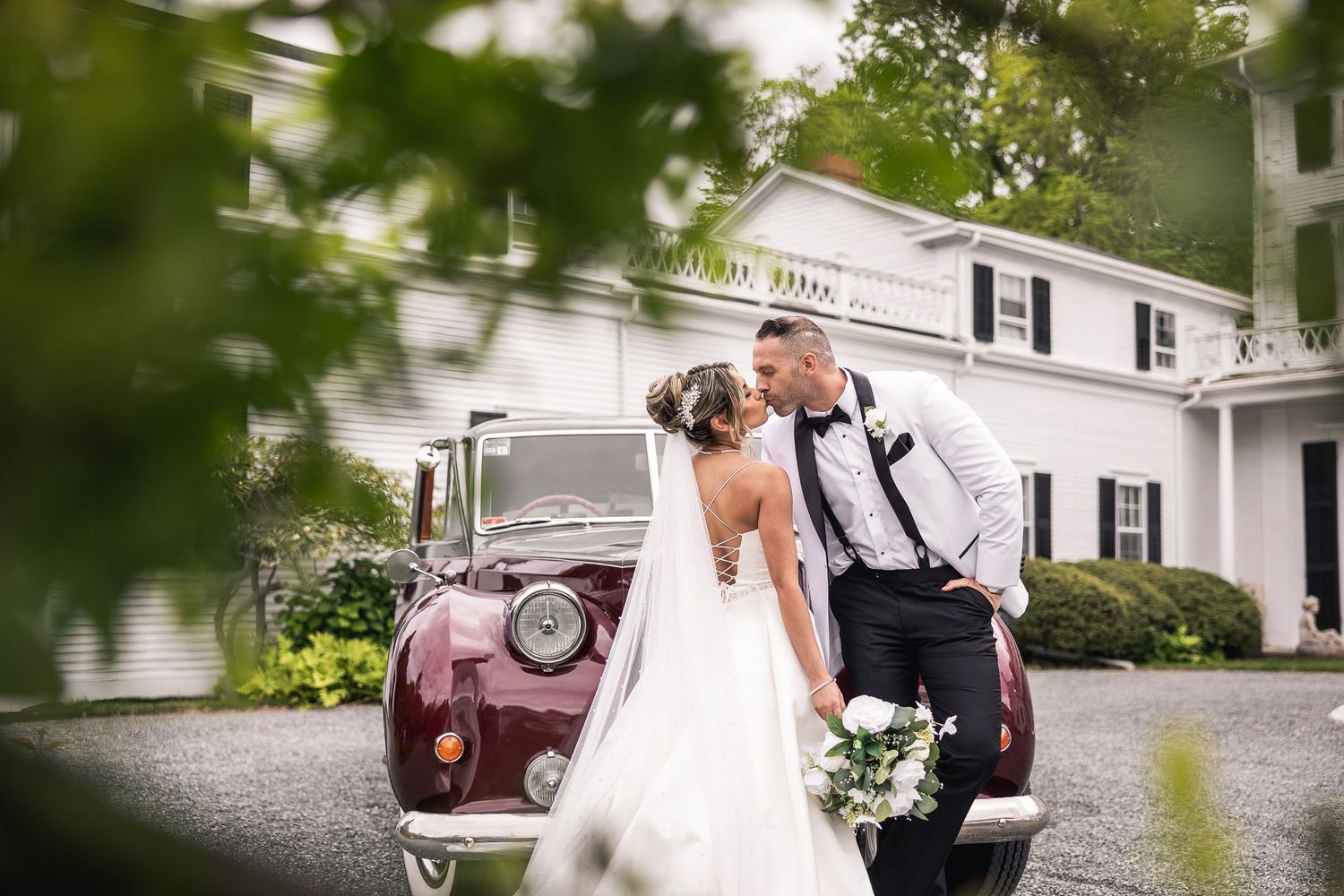 Wedding photography session taking place outside a white colonial style building.
