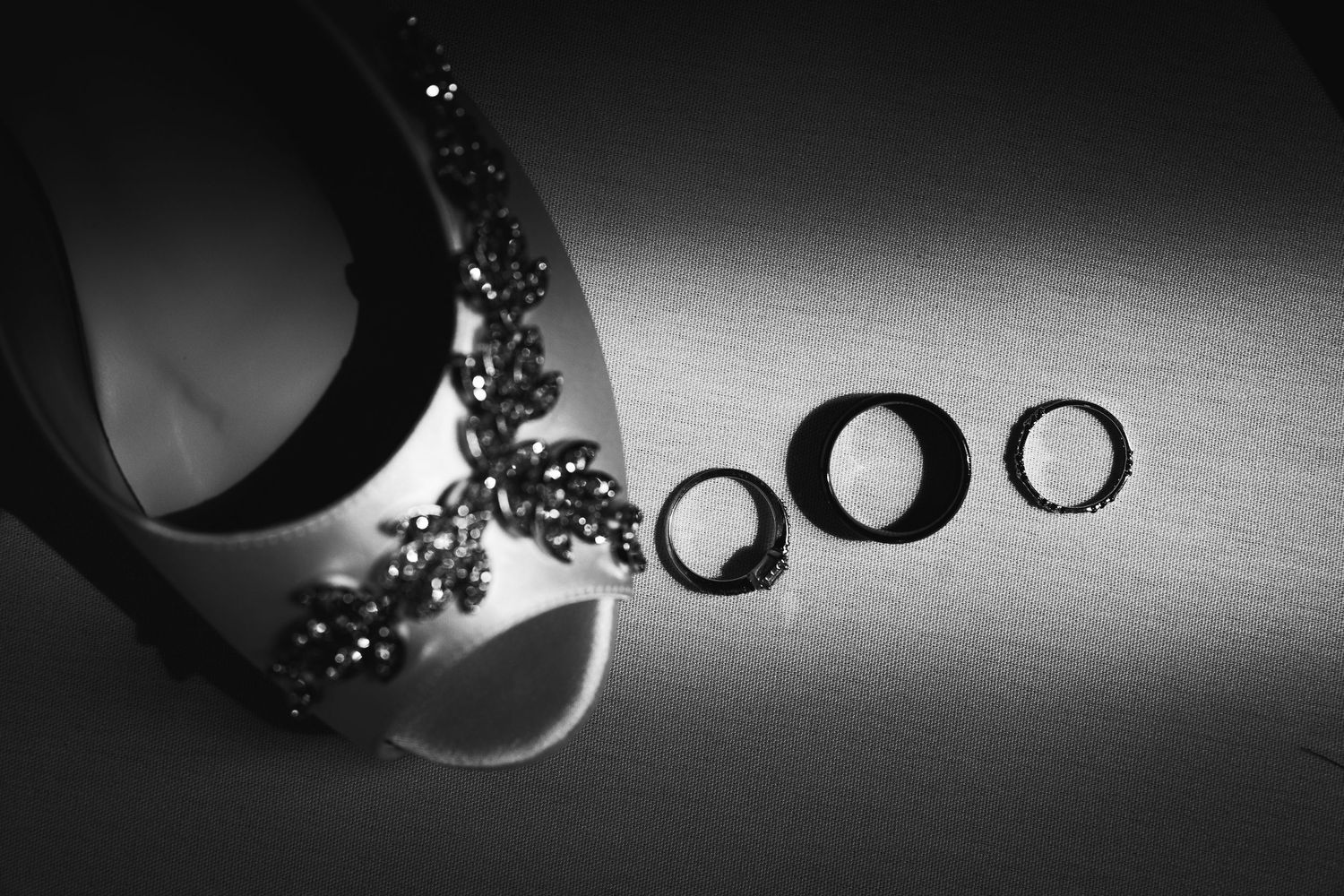 Artistic black and white composition of wedding rings with dramatic lighting.