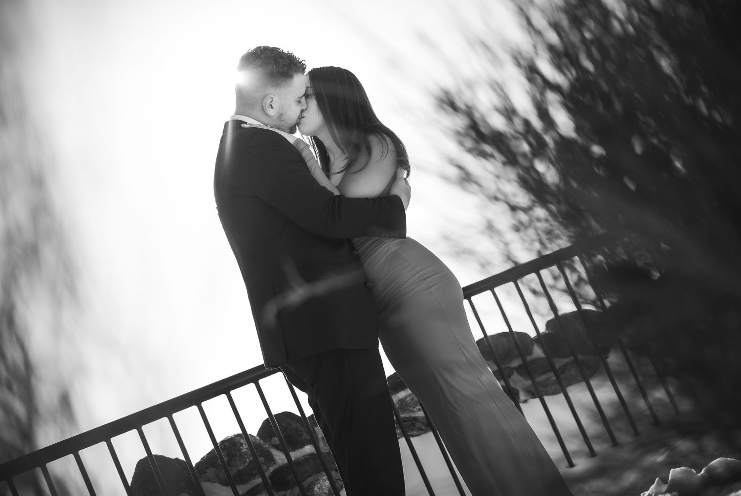 A romantic couple embraces on a balcony during sunset in a series of black and white photographs.