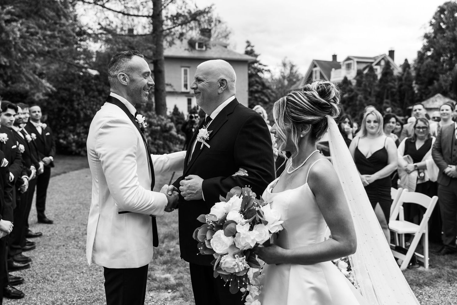 Black and white wedding ceremony moments captured in an outdoor garden setting.