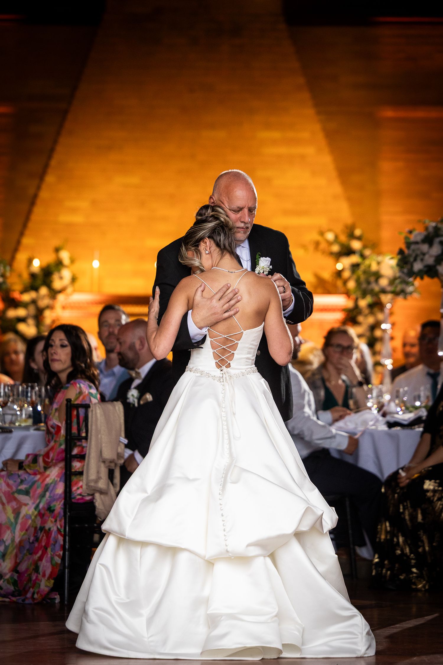 Dramatic dip during first dance at wedding reception with warm lighting.