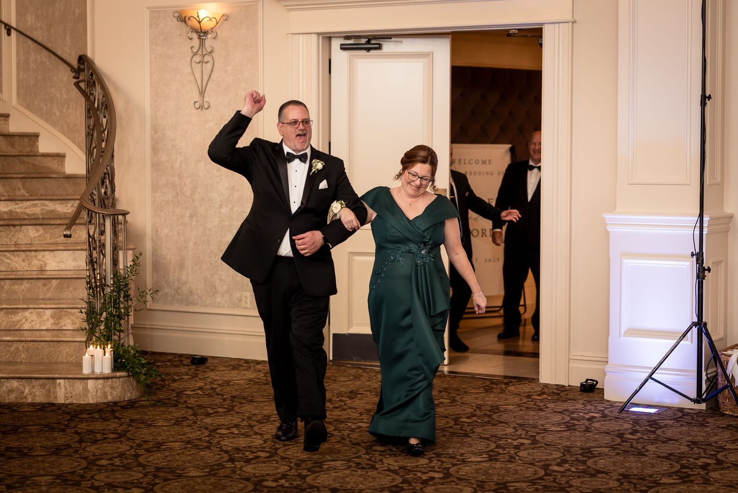 Couple sharing a playful dance moment on an ornate staircase at their wedding.
