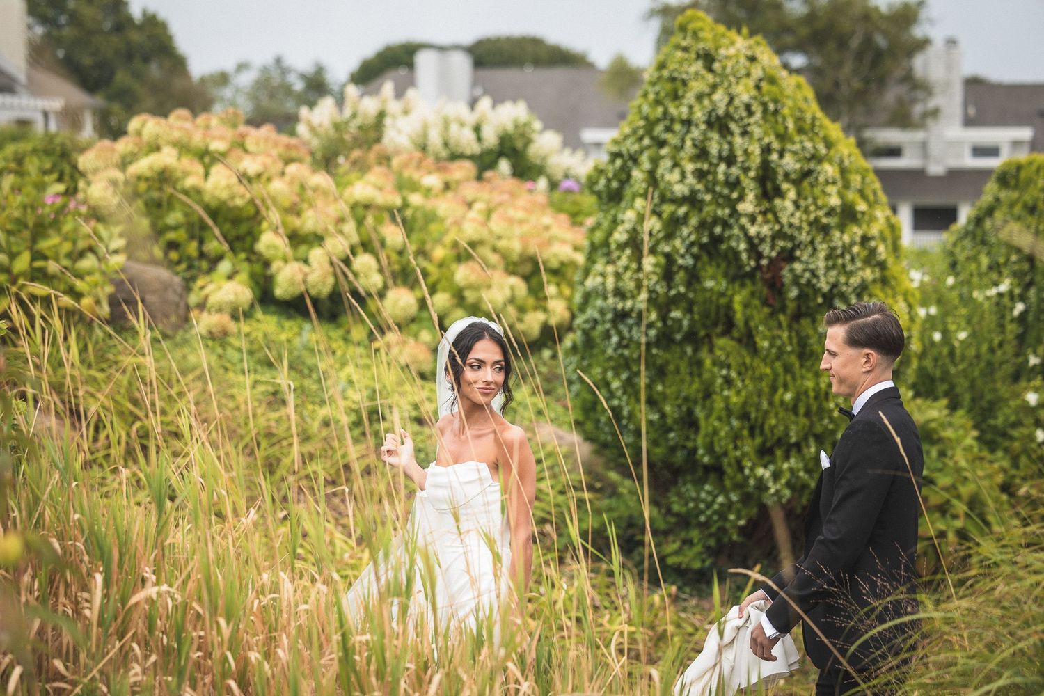 Outdoor wedding ceremony in a lush garden setting with greenery and natural light.