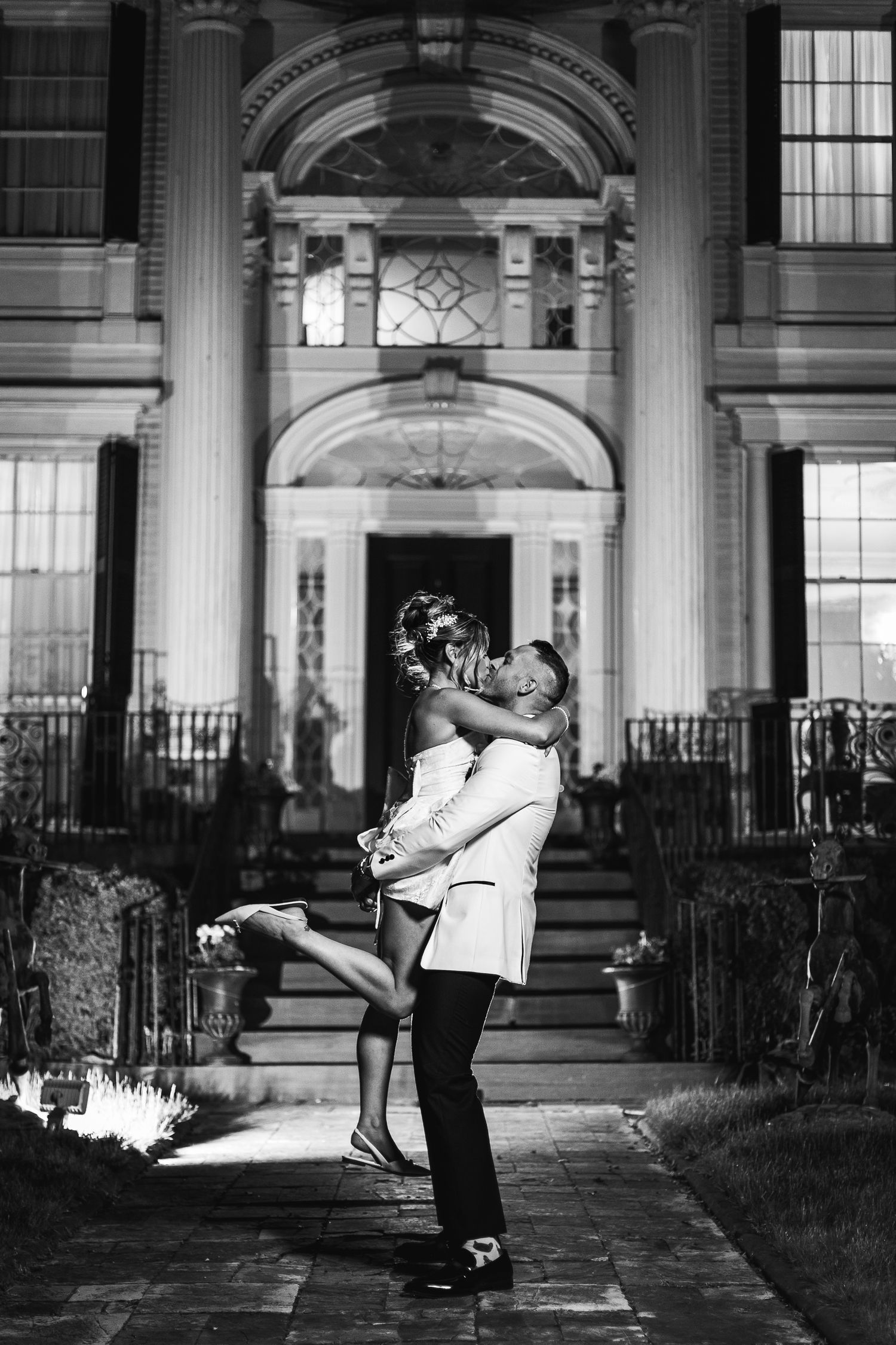 Black and white wedding dance sequence in elegant columned architecture setting.