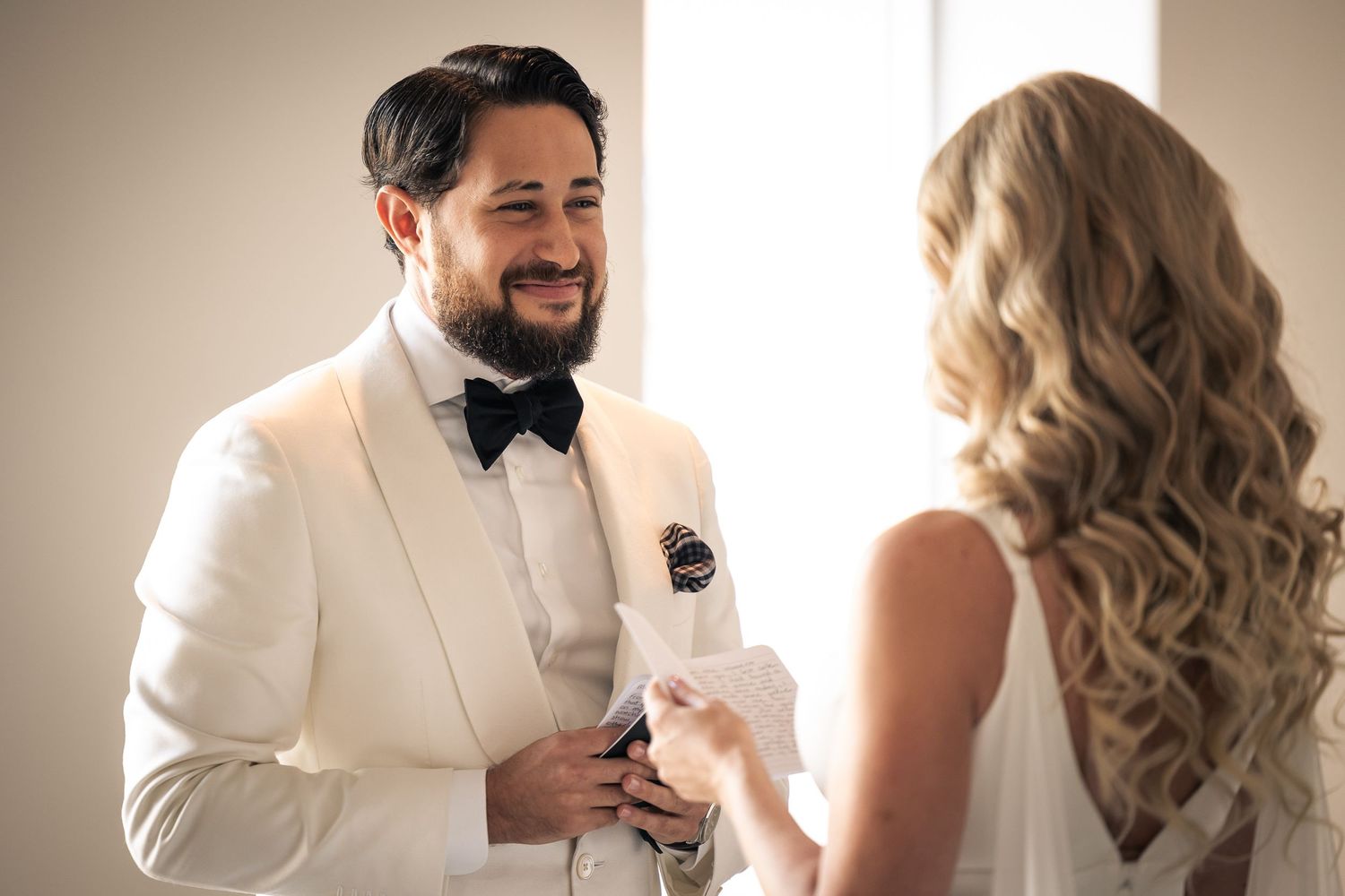 A collection of wedding photos showing candid moments between a couple in formal white attire against neutral backgrounds.