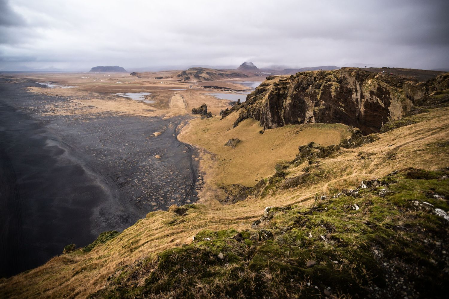 Coastal cliffs and rugged terrain overlooking the ocean in Iceland.