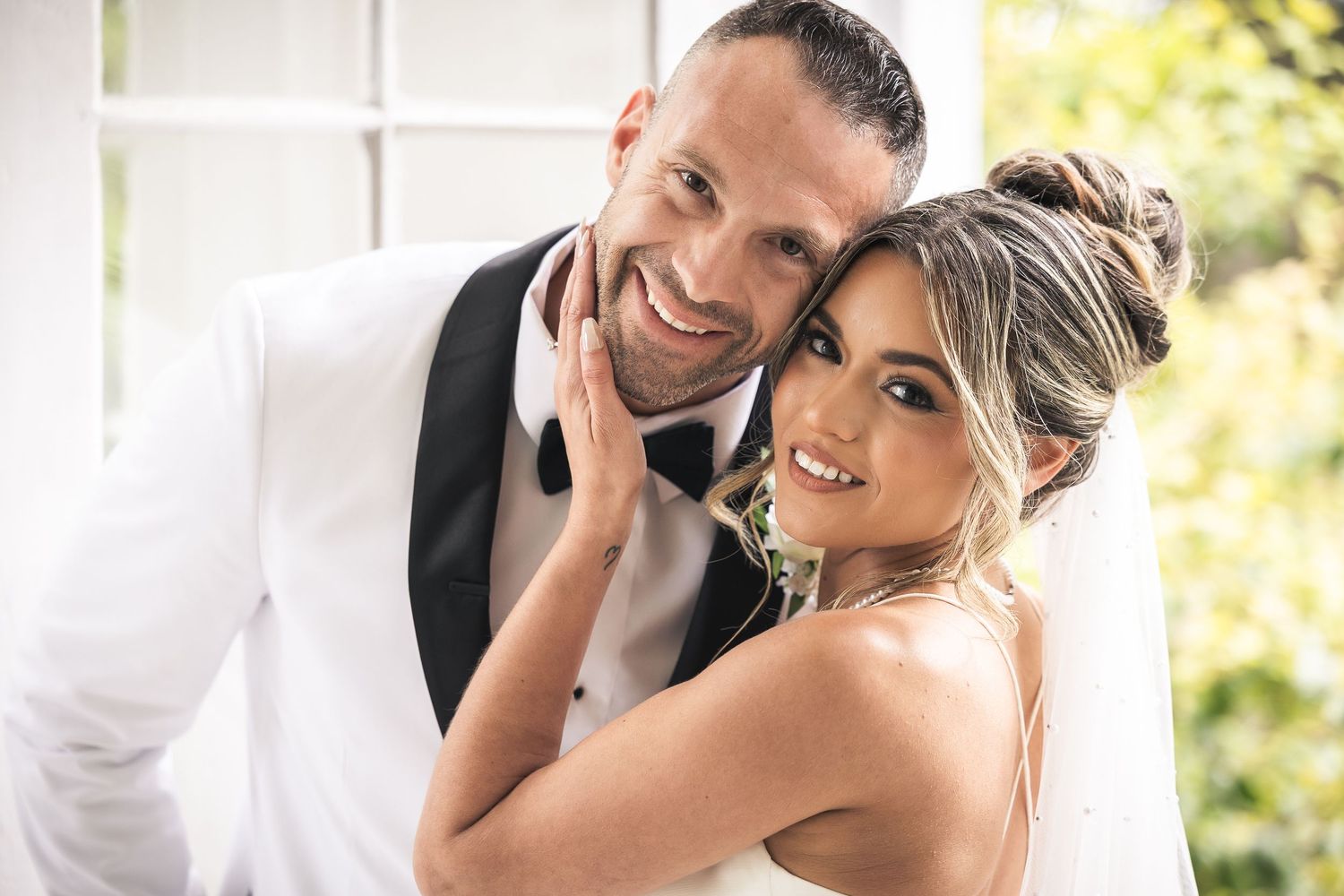 Intimate wedding couple portrait captured in soft natural light outdoors.