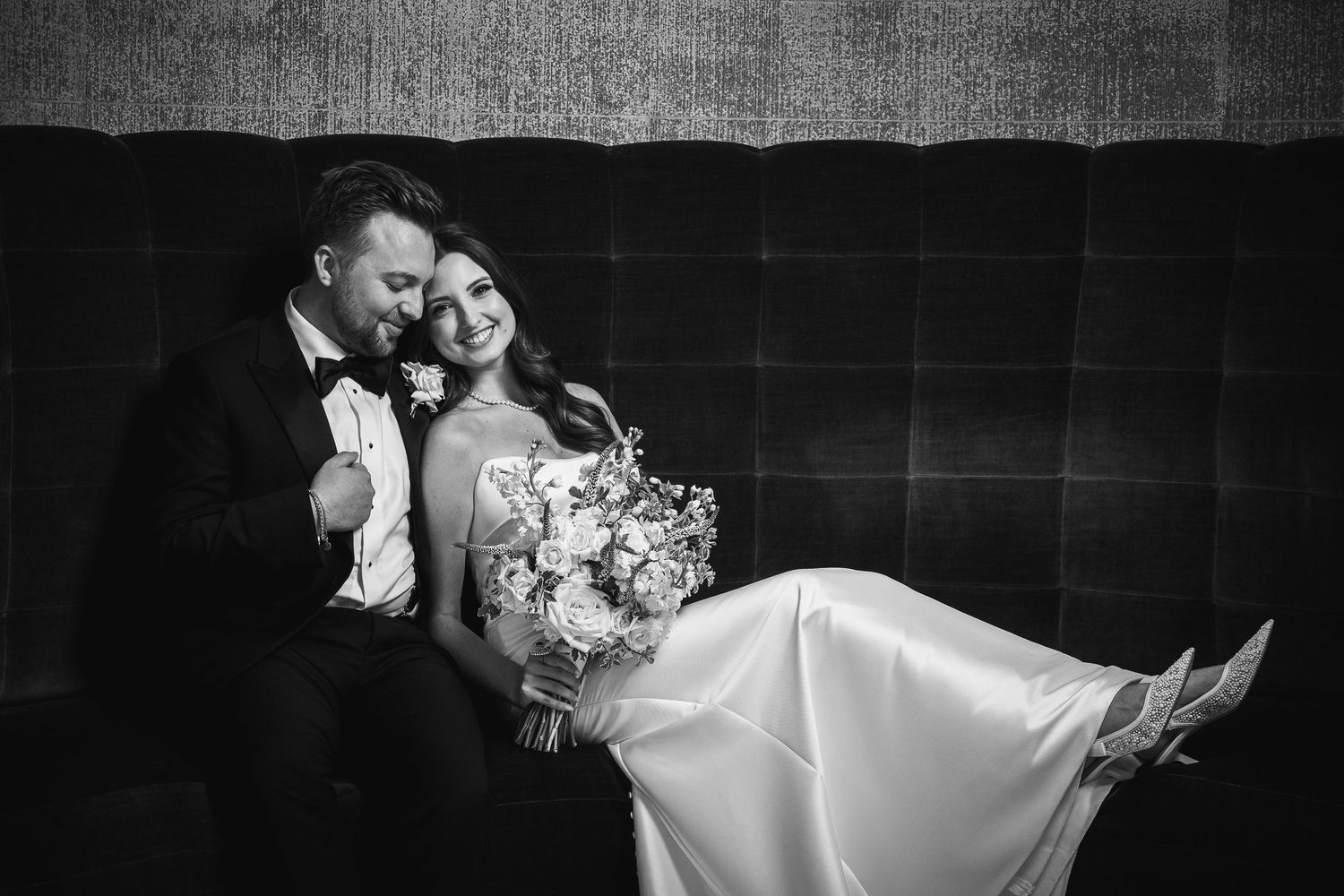Romantic black and white wedding portrait with dramatic lighting and composition.