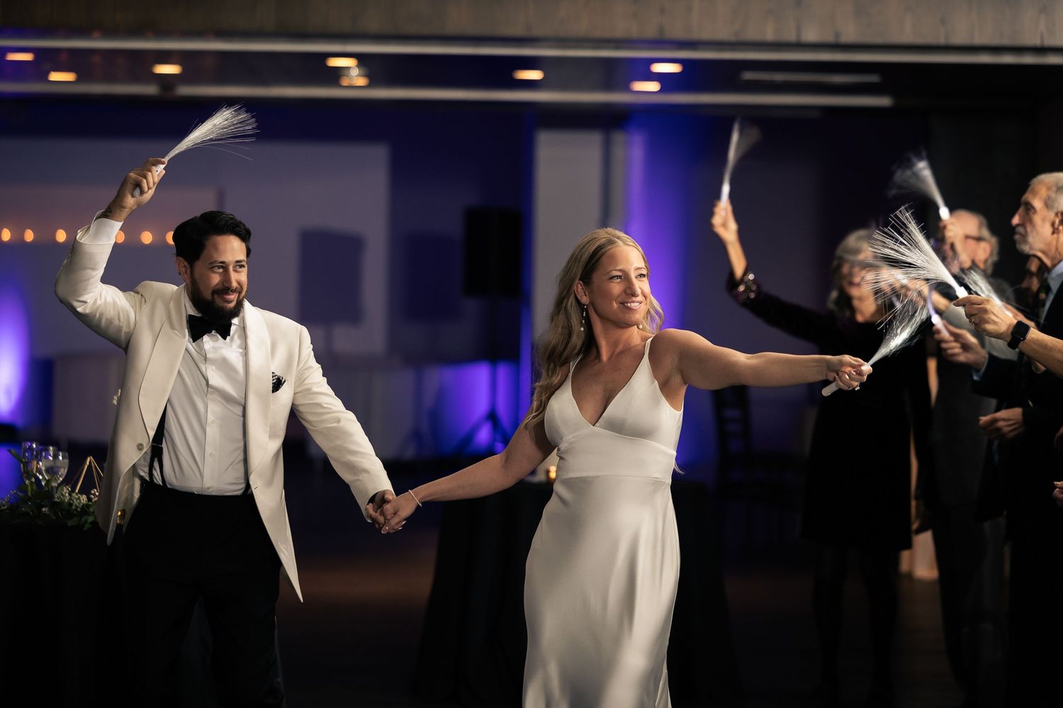 A wedding reception dance floor with couples dancing and celebrating in elegant white attire.