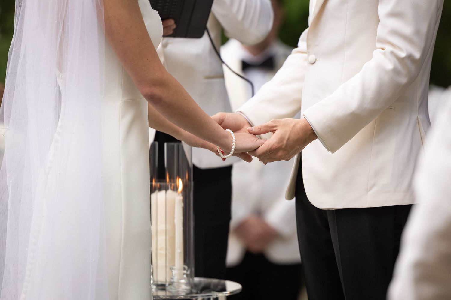 Bride and groom hold hands during their home ceremony.