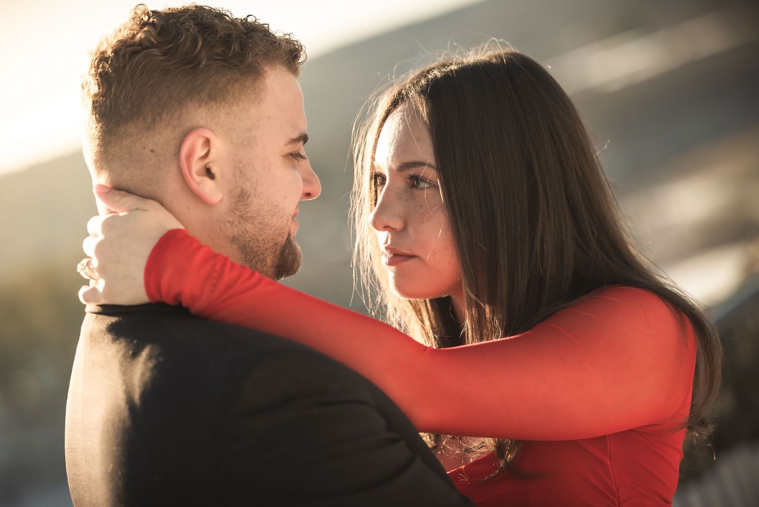 A couple in a romantic embrace with dramatic lighting, showing a tender moment in a sequence of intimate poses.