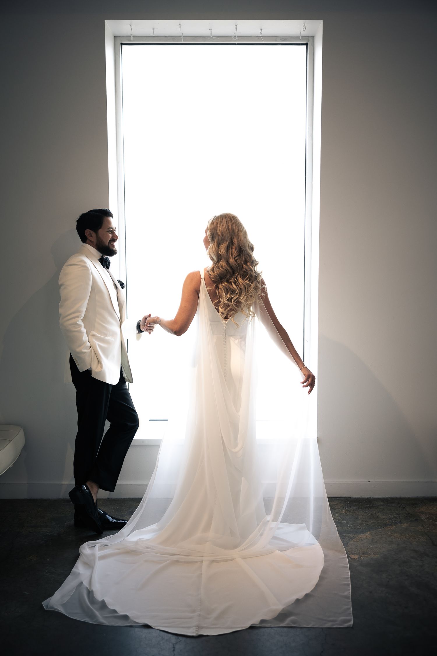 A sequence of artistic black and white wedding photos showing a couple dancing in front of a bright window.