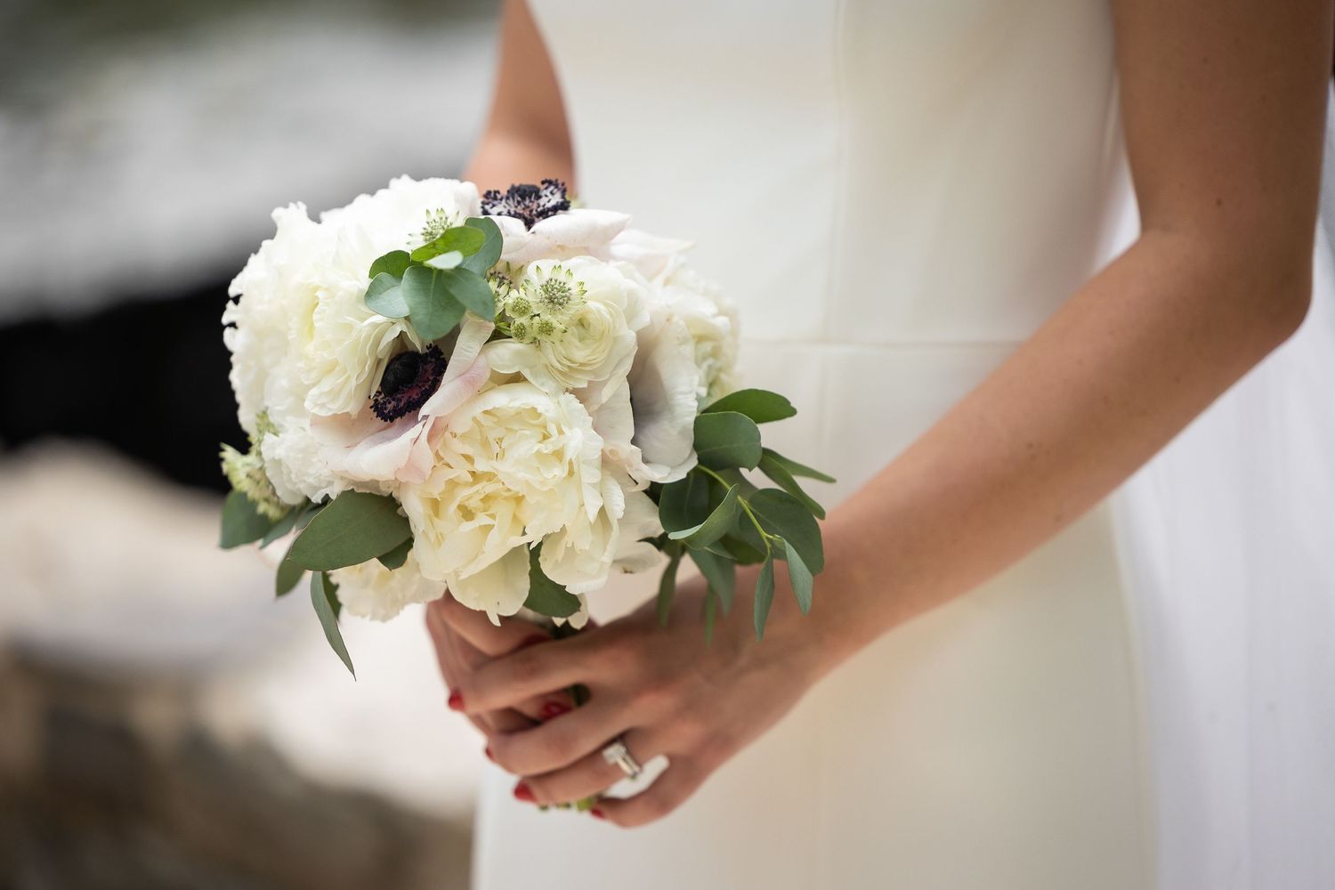 White rose and greenery wedding bouquets held by the bride.