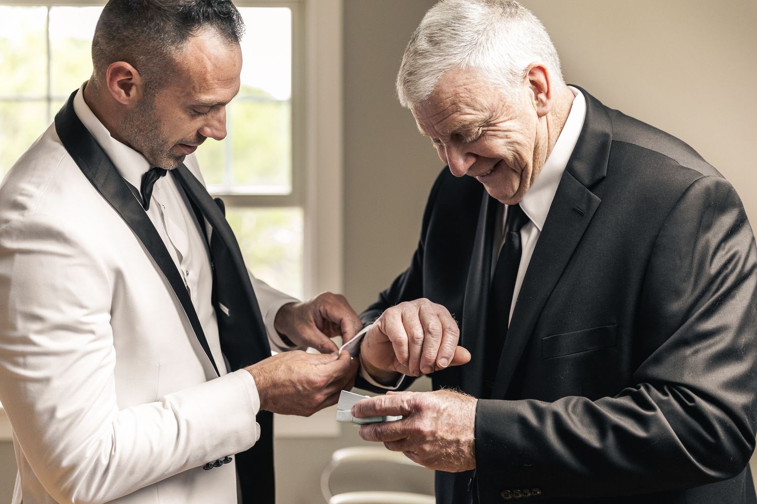 Men in formal attire adjusting their ties and preparing for a special event.