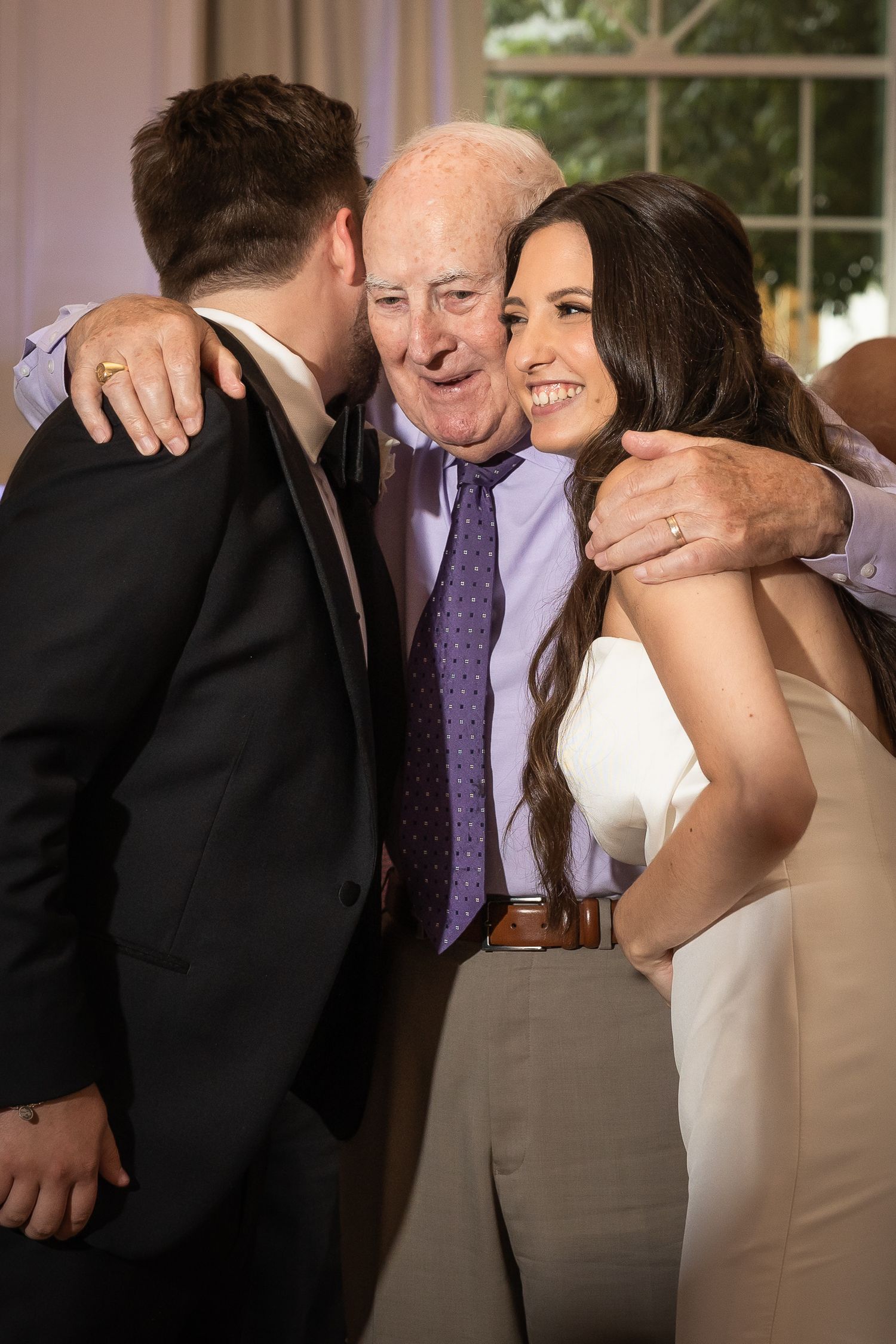 Candid moments of celebration and laughter during wedding reception toasts.