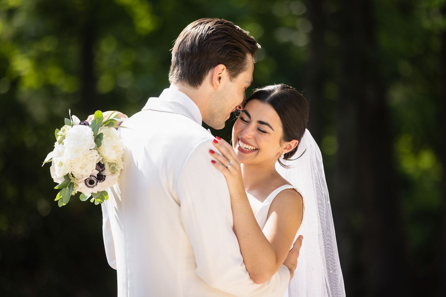 Wedding couple sharing an intimate moment in a lush garden setting.