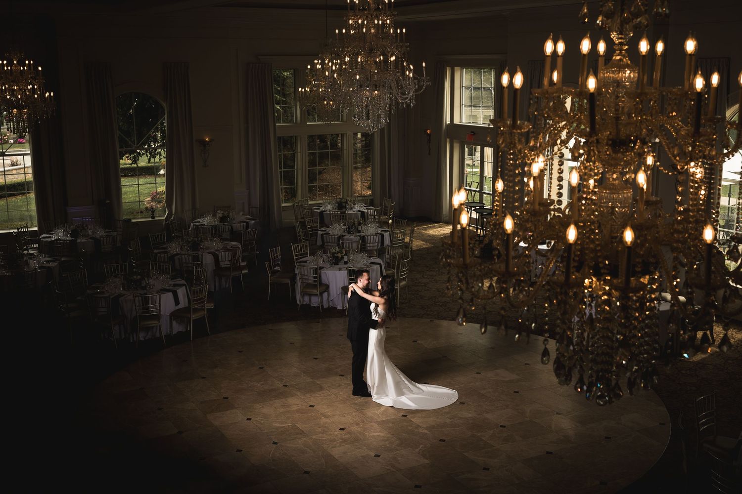 Romantic evening wedding reception photos with dramatic chandelier lighting.