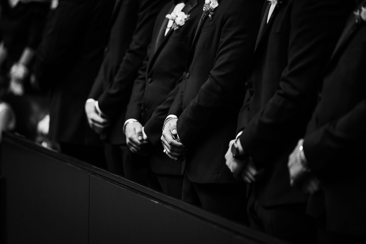 Artistic black and white portrait of groomsmen standing in formal line.