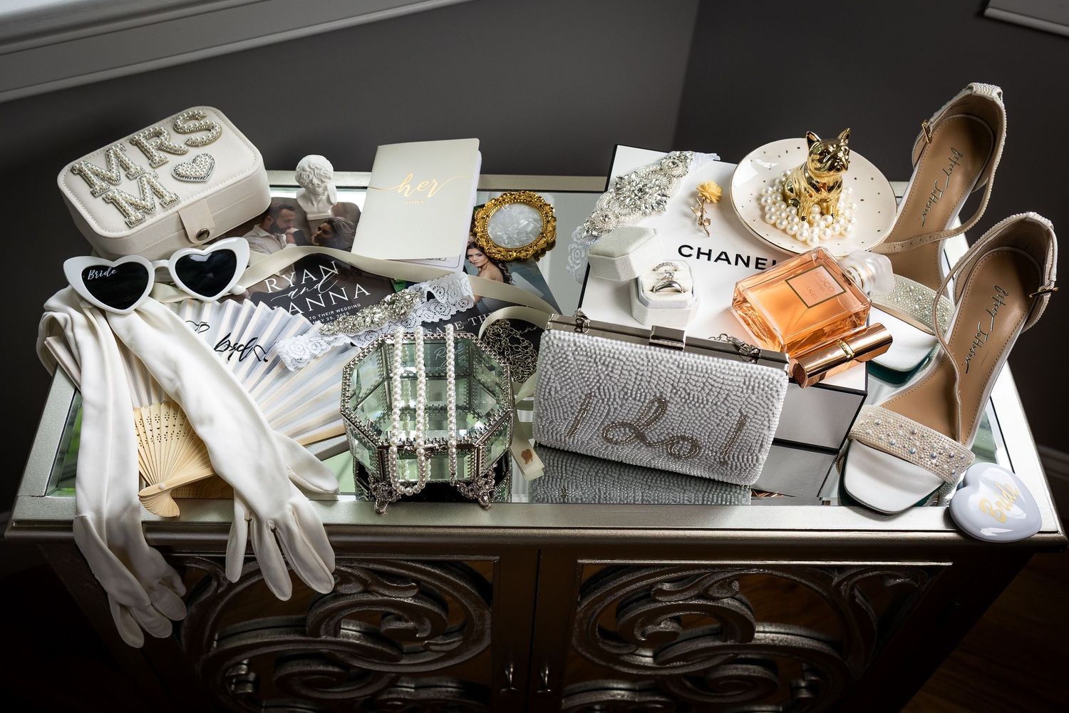 Wedding day details including shoes, jewelry, and accessories arranged on white surface.