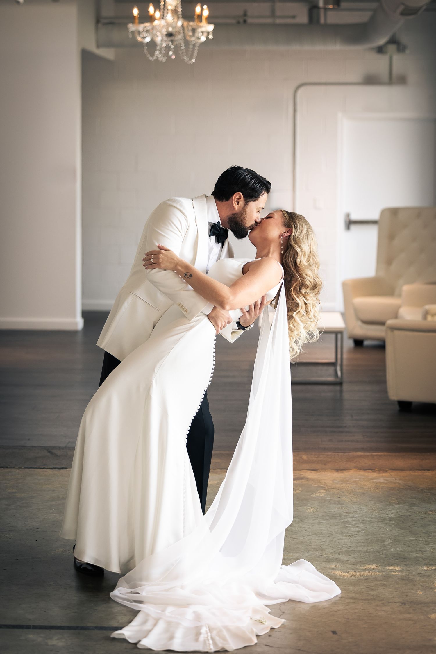 A romantic sequence of wedding photos showing a couple in white formal attire dancing in an elegant room with chandeliers.