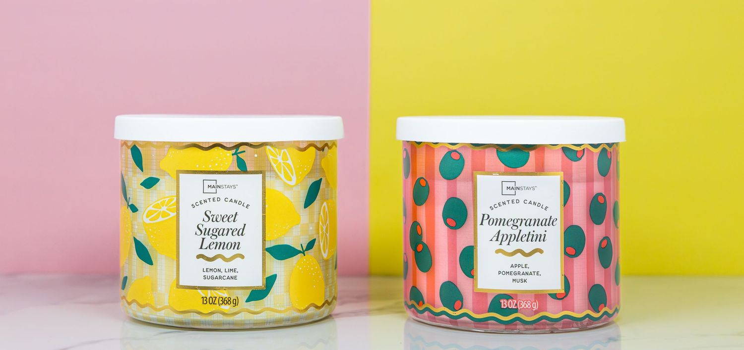 Two scented candles, Sweet Sugared Lemon and Pomegranate Appletini, displayed against a colorful pink and yellow background.