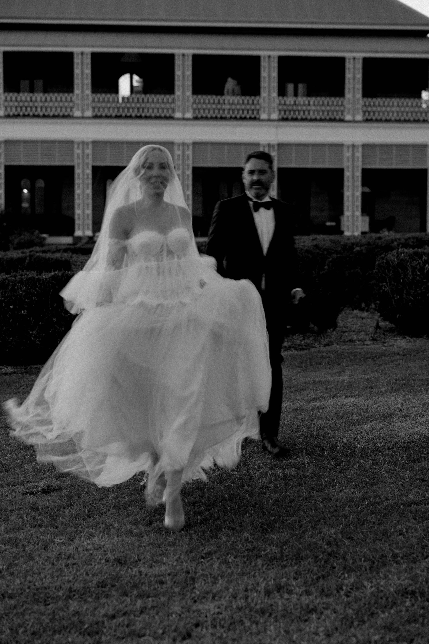 A sequence of black and white photos showing a flowing white wedding dress in motion across a grassy lawn.