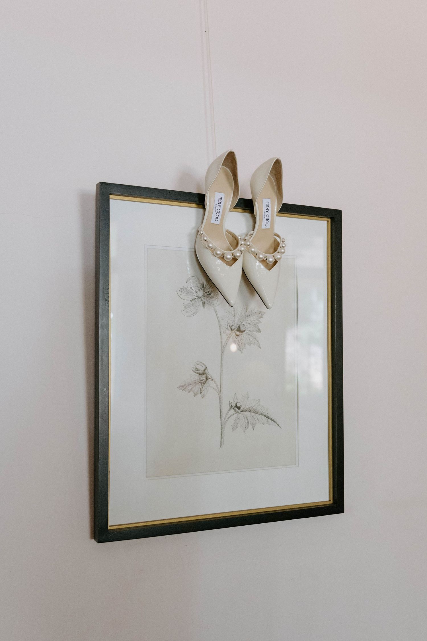White bridal shoes elegantly displayed above a framed botanical sketch  jimmy Choo shoes gabbinbar homestead Toowoomba wedding