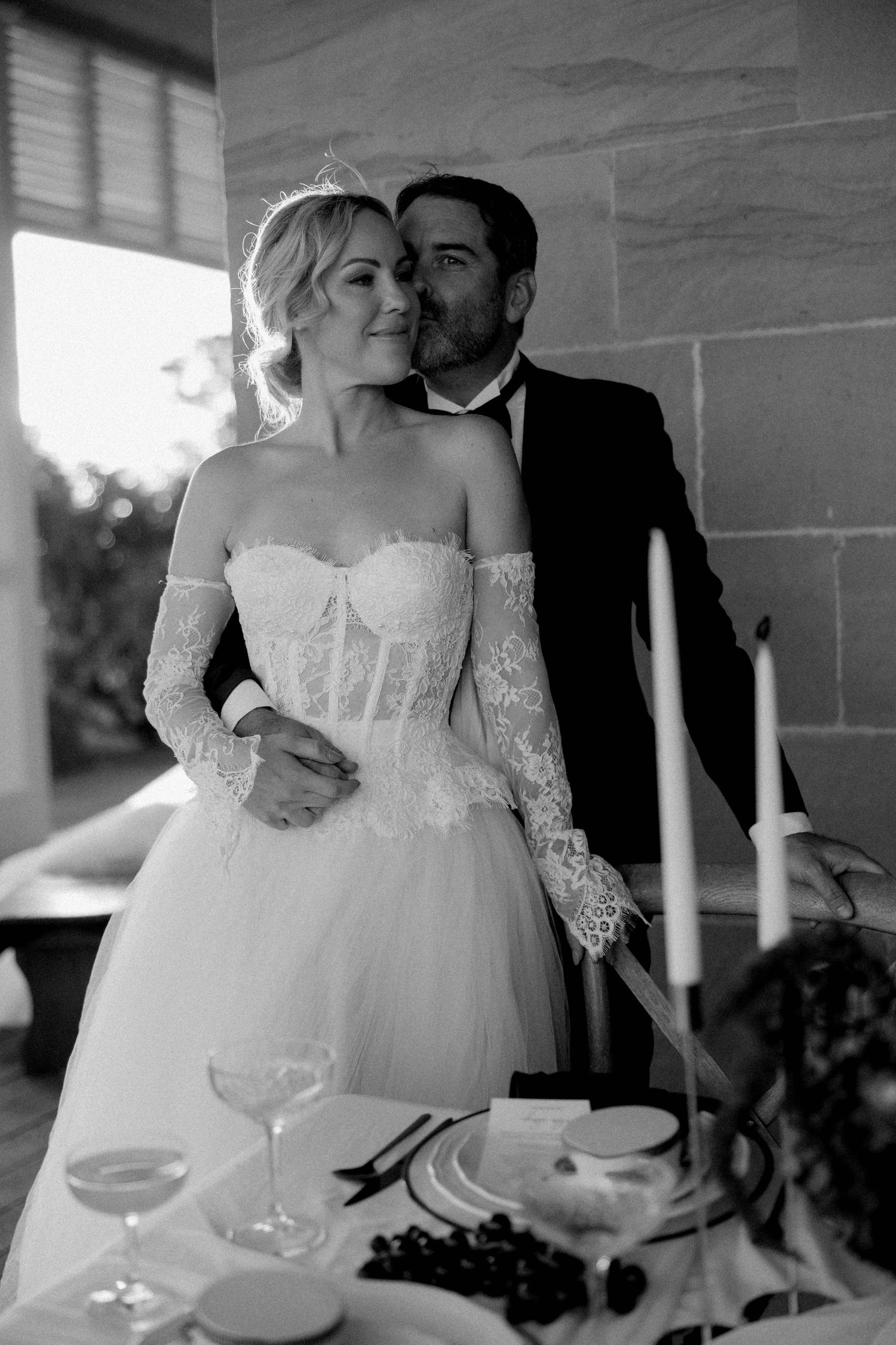A romantic wedding photo series showing close-up details of champagne glasses and a bride's lace dress in black and white.