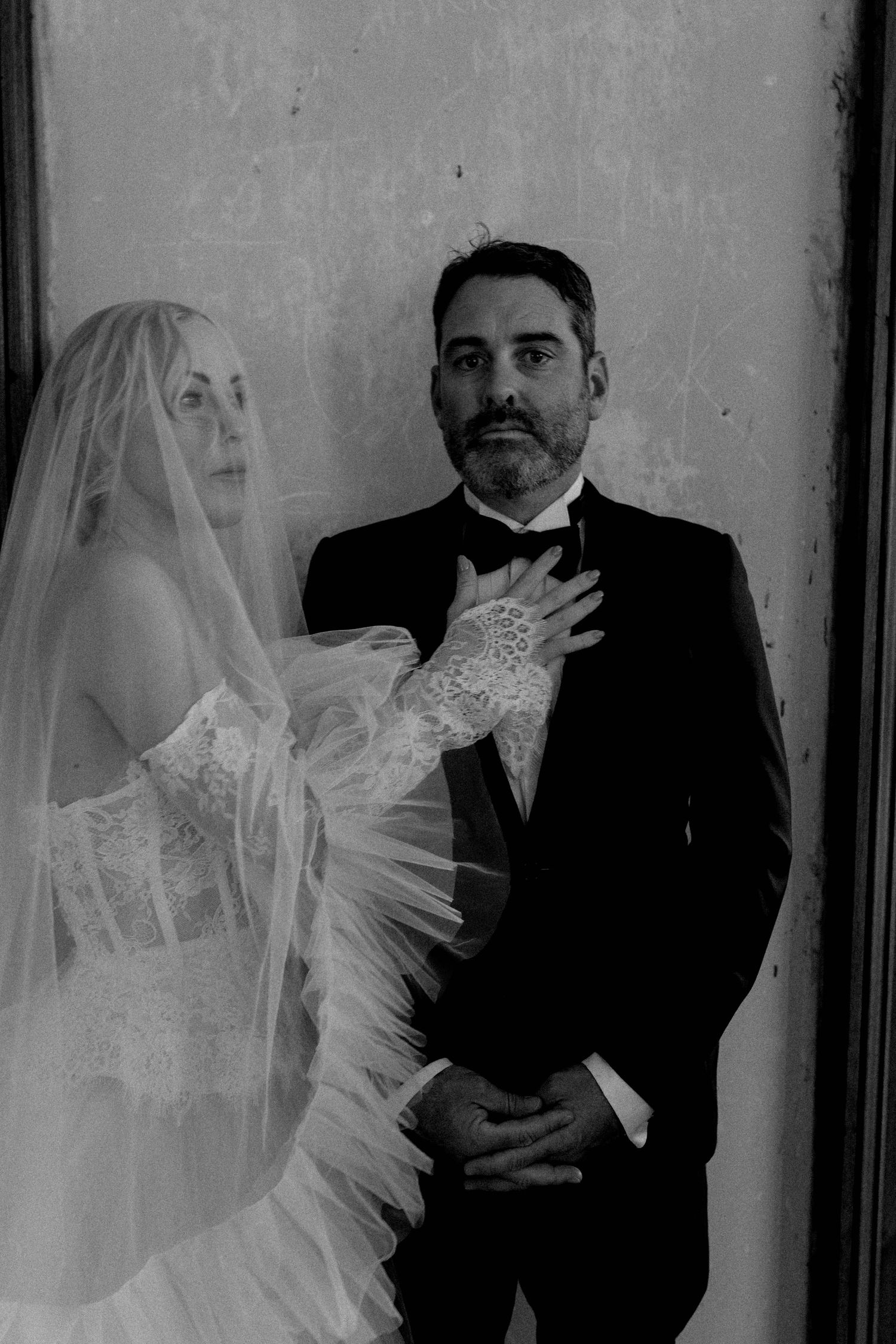 A series of vintage black and white wedding portraits showing a bride and groom in formal attire with romantic poses.