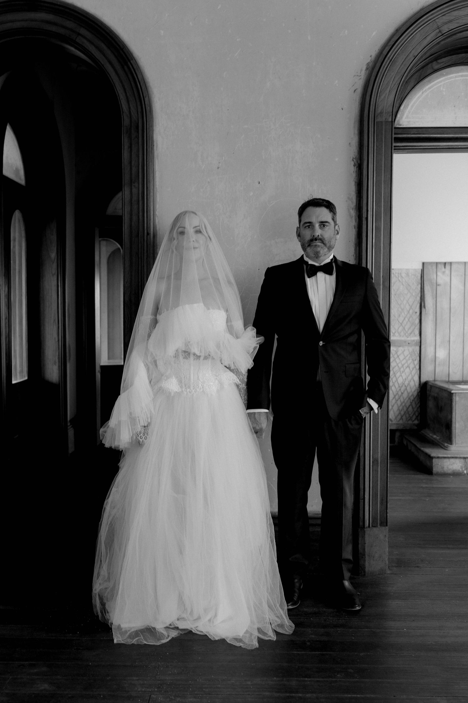 A series of vintage black and white photographs showing figures in formal attire walking through an elegant hallway.