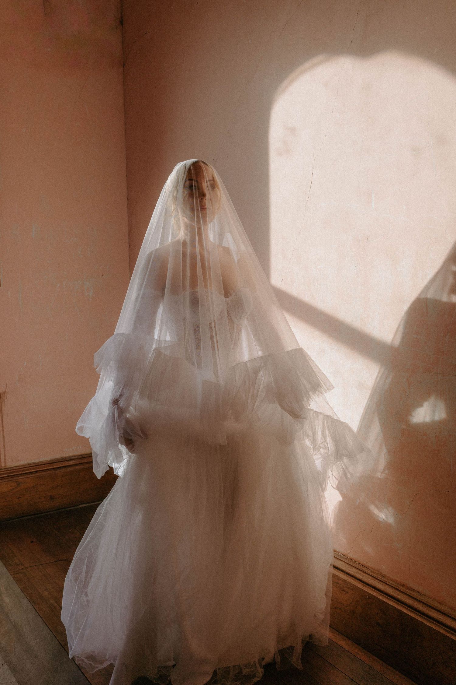 A series of ethereal photos showing a flowing white wedding dress and veil in soft, diffused natural light.