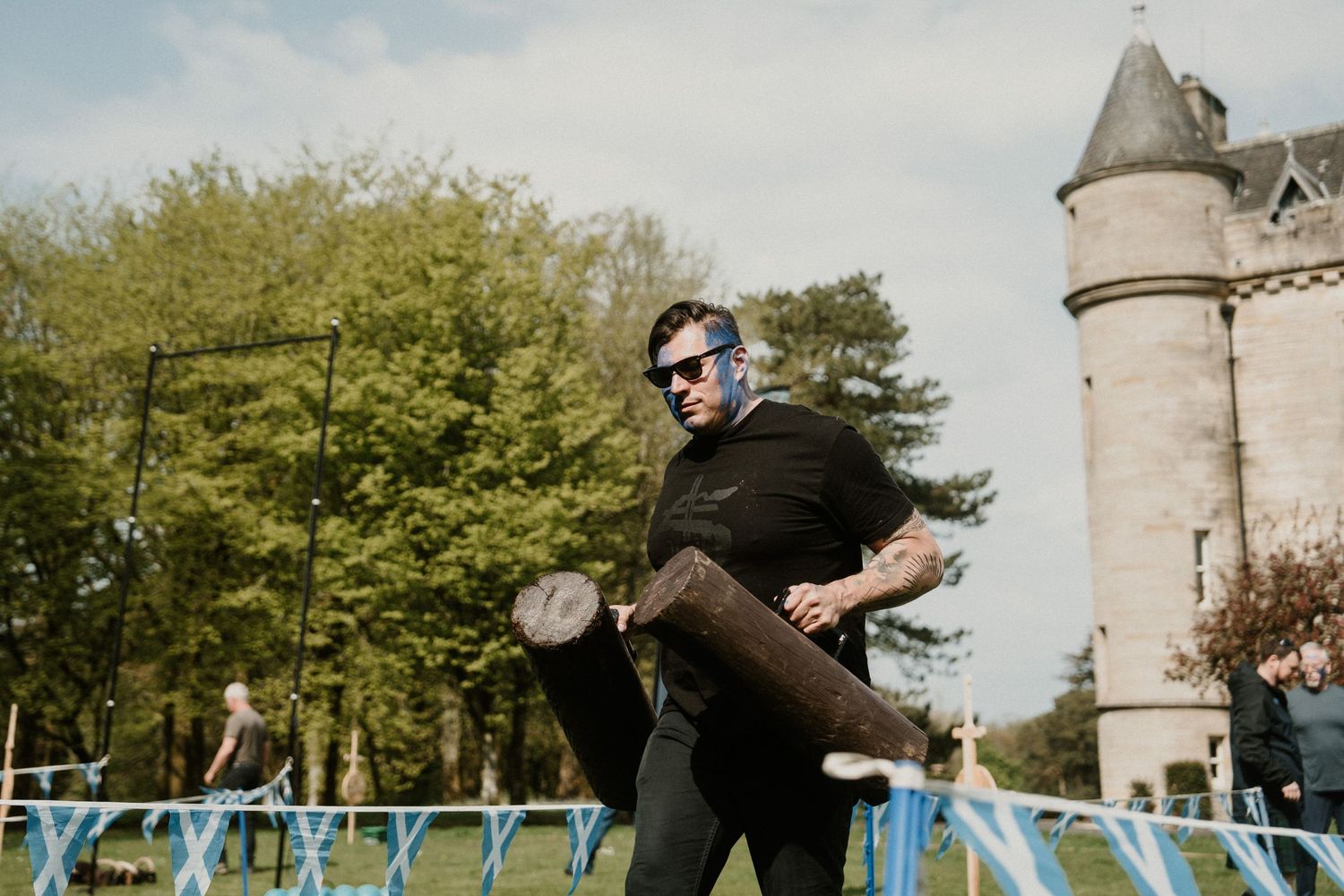 A person in black clothing jumps energetically in front of a castle tower.