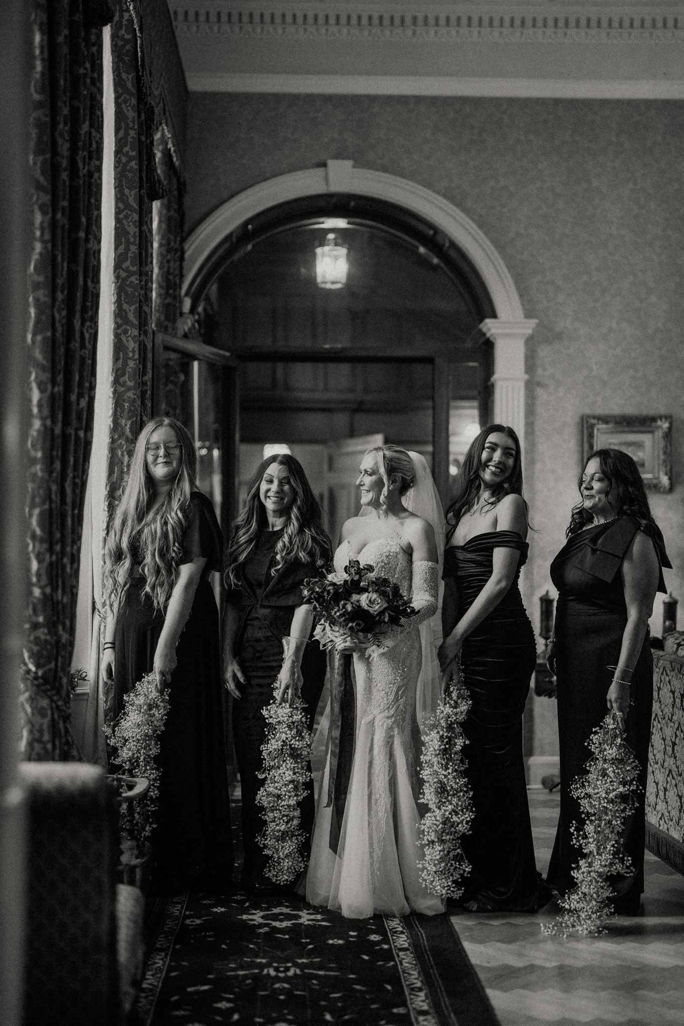 Black and white photograph of a wedding celebration in a classic architectural setting.