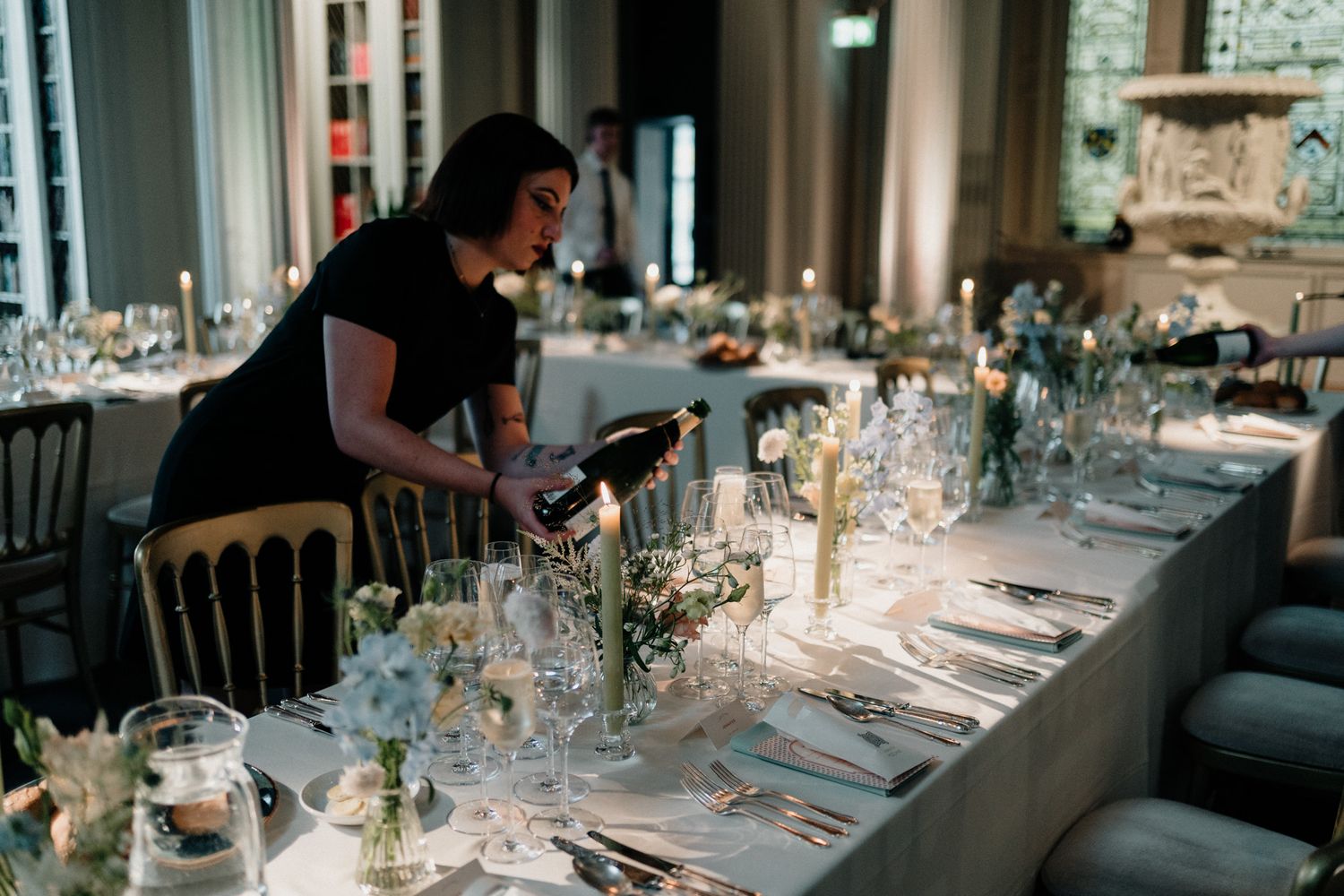 Wedding reception venue with elegant table settings and ambient lighting.