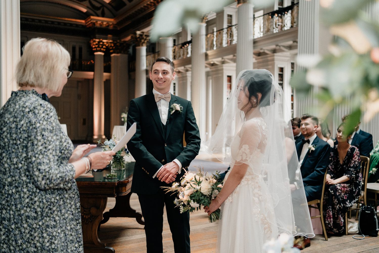 Wedding ceremony moments captured in a historic venue with classical architecture.